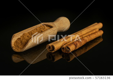 Dry brown cinnamon isolated on black glass 57163136