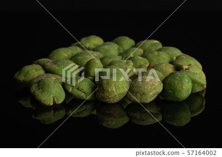 Green wasabi peanut isolated on black glass Green wasabi peanut isolated on black glass 57164002