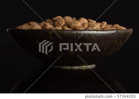 Choco balls cereal isolated on black glass Choco balls cereal isolated on black glass 57164203