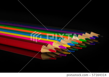 Vibrant colored pencil isolated on black glass Vibrant colored pencil isolated on black glass 57164314