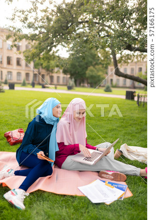 Students wearing bright hijabs feeling cheerful studying together 57166175