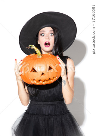 Young woman in hat and dress as a witch on white background 57166595