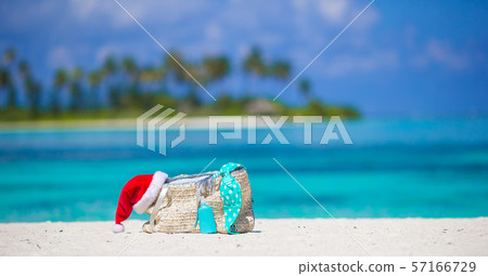 Beach accessories with Santa Hat on white tropical beach 57166729