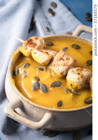 Cream soup with pumpkin and chicken skewers. Cream soup with pumpkin and chicken skewers. 57168579