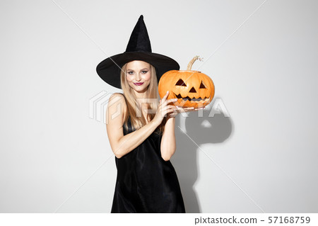 Young woman in hat as a witch on white background 57168759
