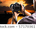 Young man holds black modern digital camera 57170361