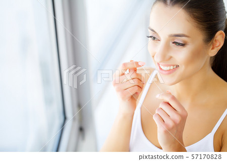 Beautiful young woman teeth close up with copy space on the right side. Isolated over green 57170828