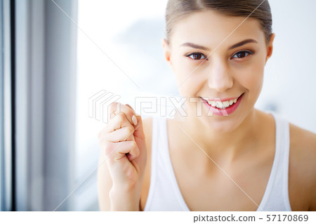 Woman Using Teeth Whitening Strip For Beautiful White Smile. High Resolution Image Woman Using Teeth Whitening Strip For Beautiful White Smile. High Resolution Image 57170869