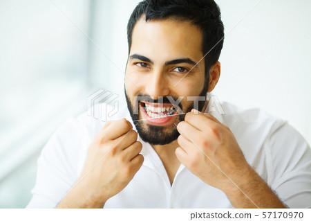 Dental Health. Man With Beautiful Smile Flossing Healthy Teeth. High Resolution Image Dental Health. Man With Beautiful Smile Flossing Healthy Teeth. High Resolution Image 57170970