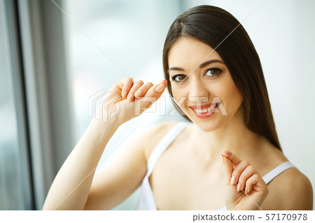 Teeth Care. Beautiful Smiling Woman Flossing Healthy White Teeth. High Resolution Image 57170978