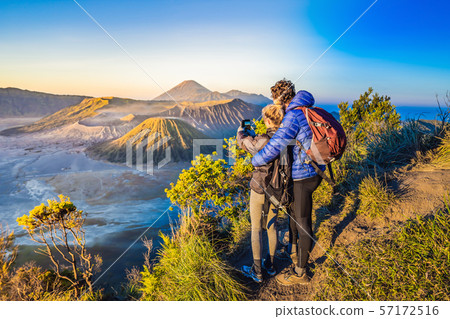 Young couple man and woman meet the sunrise at the Bromo Tengger Semeru National Park on the Java 57172516