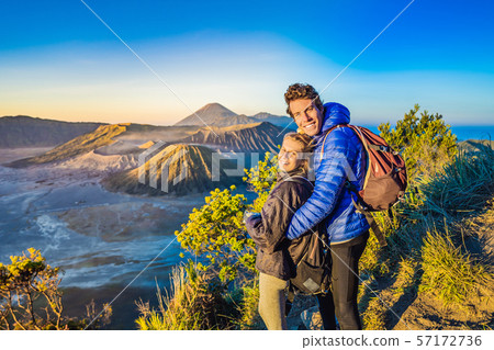 Young couple man and woman meet the sunrise at the Bromo Tengger Semeru National Park on the Java 57172736