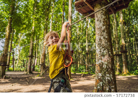 Little boy in a rope park. Active physical recreation of the child in the fresh air in the park 57172738