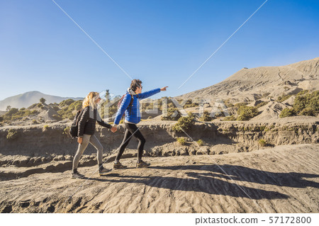 Young couple man and woman visit the Bromo volcano at the Tengger Semeru National Park on the Java 57172800