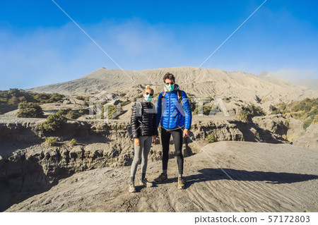 Young couple man and woman visit the Bromo volcano at the Tengger Semeru National Park on Java Young couple man and woman visit the Bromo volcano at the Tengger Semeru National Park on Java 57172803