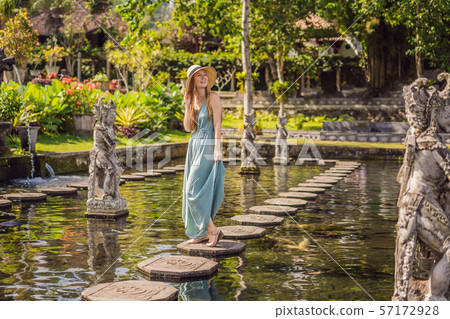 Young woman tourist in Taman Tirtagangga, Water palace, Water park, Bali Indonesia Young woman tourist in Taman Tirtagangga, Water palace, Water park, Bali Indonesia 57172928