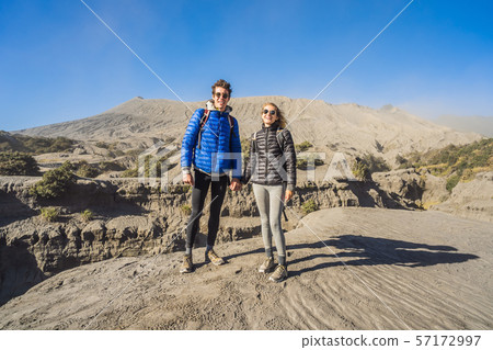 Young couple man and woman visit the Bromo volcano at the Tengger Semeru National Park on the Java 57172997