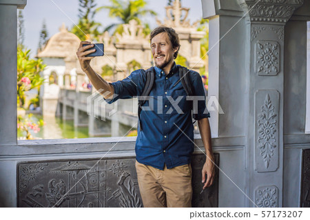 Young man in Water Palace Soekasada Taman Ujung Ruins on Bali Island in Indonesia. Amazing old 57173207