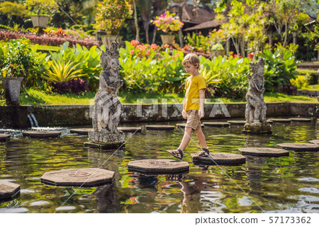 Boy tourist in Taman Tirtagangga, Water palace, Water park, Bali Indonesia. Traveling with children 57173362