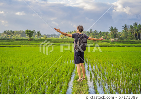 Male tourist with a backpack goes on the rice field 57173389