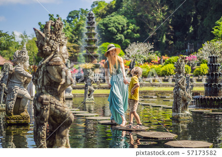 Mom and son tourists in Taman Tirtagangga, Water palace, Water park, Bali Indonesia. Traveling with Mom and son tourists in Taman Tirtagangga, Water palace, Water park, Bali Indonesia. Traveling with 57173582