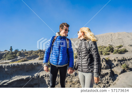 Young couple man and woman visit the Bromo volcano at the Tengger Semeru National Park on the Java Young couple man and woman visit the Bromo volcano at the Tengger Semeru National Park on the Java 57173634