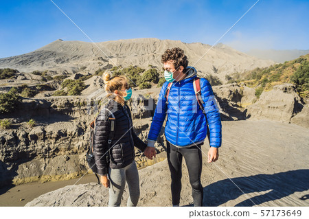 Young couple man and woman visit the Bromo volcano at the Tengger Semeru National Park on Java 57173649