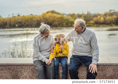 Senior couple with baby grandson in the autumn park. Great-grandmother, great-grandfather and great Senior couple with baby grandson in the autumn park. Great-grandmother, great-grandfather and great 57173651