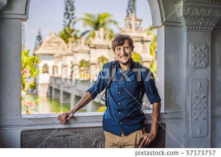 Young man in Water Palace Soekasada Taman Ujung Ruins on Bali Island in Indonesia. Amazing old Young man in Water Palace Soekasada Taman Ujung Ruins on Bali Island in Indonesia. Amazing old 57173757