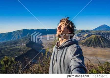Young man meets the sunrise at the Bromo Tengger Semeru National Park on the Java Island, Indonesia 57173855