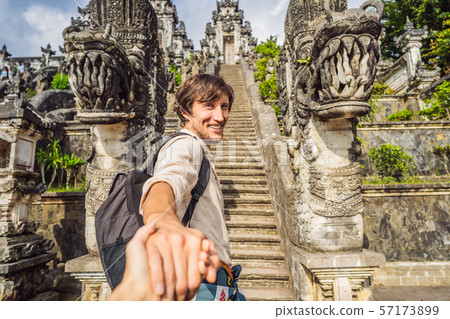 follow me photo. Young man tourist on background of Three stone ladders in beautiful Pura Lempuyang follow me photo. Young man tourist on background of Three stone ladders in beautiful Pura Lempuyang 57173899