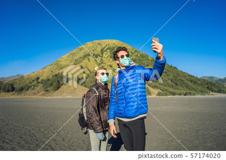 Young man and woman tourists make a selfie in the Bromo Tengger Semeru National Park on the Java 57174020