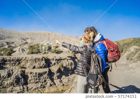 Young couple man and woman visit the Bromo volcano at the Tengger Semeru National Park on Java 57174151