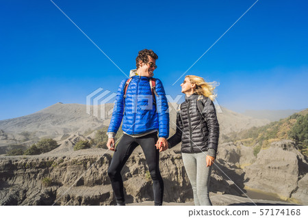 Young couple man and woman visit the Bromo volcano at the Tengger Semeru National Park on the Java Young couple man and woman visit the Bromo volcano at the Tengger Semeru National Park on the Java 57174168