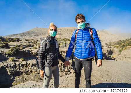 Young couple man and woman visit the Bromo volcano at the Tengger Semeru National Park on Java 57174172