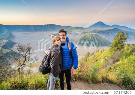 Young couple man and woman meet the sunrise at the Bromo Tengger Semeru National Park on the Java 57174205