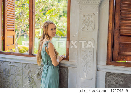 Young woman in dress in Water Palace Soekasada Taman Ujung Ruins on Bali Island in Indonesia 57174249
