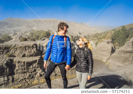 Young couple man and woman visit the Bromo volcano at the Tengger Semeru National Park on the Java 57174251
