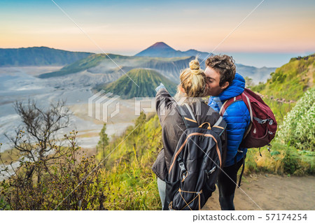 Young couple man and woman meet the sunrise at the Bromo Tengger Semeru National Park on the Java Young couple man and woman meet the sunrise at the Bromo Tengger Semeru National Park on the Java 57174254