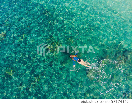Happy woman in snorkeling mask dive underwater with tropical fishes in coral reef sea pool. Travel 57174342