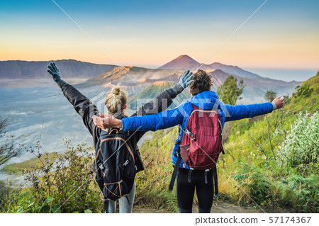 Young couple man and woman meet the sunrise at the Bromo Tengger Semeru National Park on the Java 57174367