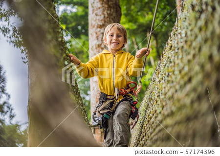 Little boy in a rope park. Active physical recreation of the child in the fresh air in the park 57174396