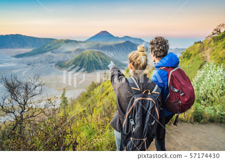 Young couple man and woman meet the sunrise at the Bromo Tengger Semeru National Park on the Java 57174430