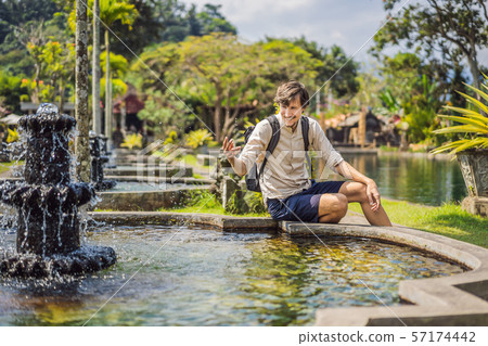 Young man tourist in Taman Tirtagangga, Water palace, Water park, Bali Indonesia 57174442