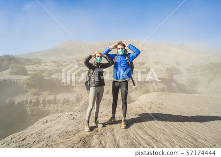 Young couple man and woman visit the Bromo volcano at the Tengger Semeru National Park on Java 57174444