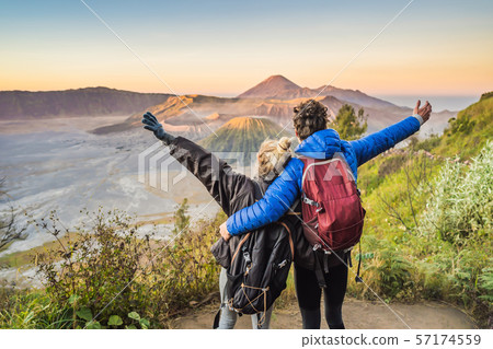Young couple man and woman meet the sunrise at the Bromo Tengger Semeru National Park on the Java Young couple man and woman meet the sunrise at the Bromo Tengger Semeru National Park on the Java 57174559