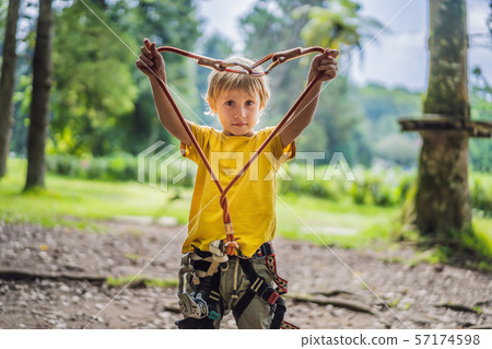Little boy in a rope park. Active physical recreation of the child in the fresh air in the park Little boy in a rope park. Active physical recreation of the child in the fresh air in the park 57174598