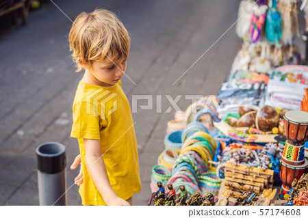 Boy at a market in Ubud, Bali. Typical souvenir shop selling souvenirs and handicrafts of Bali at 57174608