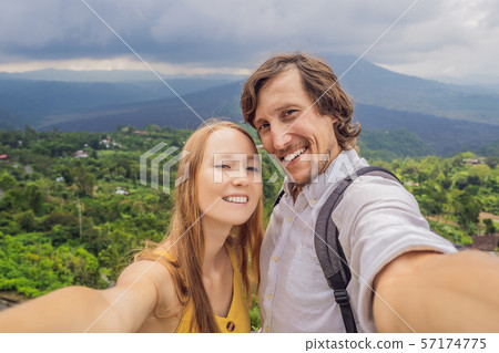 Man and woman making selfie on background of Batur volcano and Agung mountain view at morning from 57174775