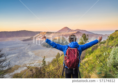 Young man meets the sunrise at the Bromo Tengger Semeru National Park on the Java Island, Indonesia 57174812